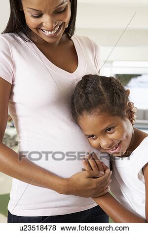 Stock Photo - Daughter Listening To Pregnant Mother's Stomach. Fotosearch
