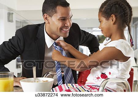 Picture - Daughter Straightens Father's Tie Before He Leaves For Work. Fotosearch