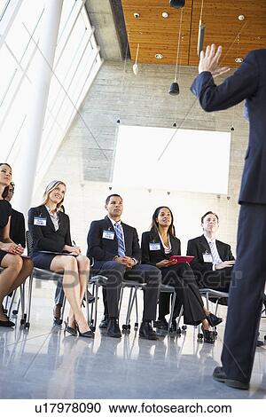 Stock Image - Delegates Listening To Speaker At Conference. Fotosearch