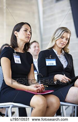 Stock Image - Delegates Listening To Speaker At Conference. Fotosearch