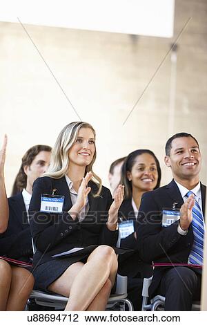 Stock Image - Delegates Listening To Speaker At Conference. Fotosearch