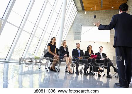 Stock Photograph - Delegates Listening To Speaker At Conference. Fotosearch
