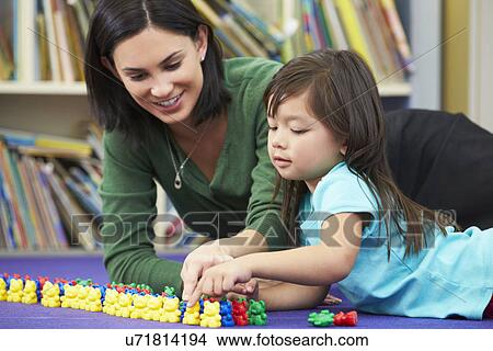 Picture - Elementary Pupil Counting With Teacher In Classroom. Fotosearch