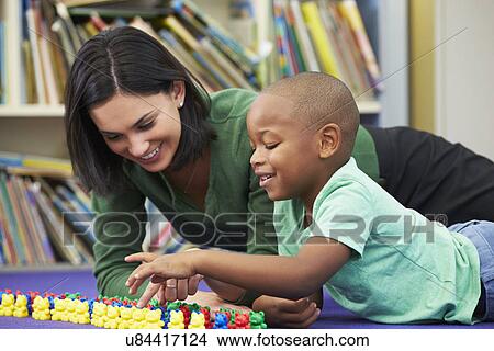 Picture - Elementary Pupil Counting With Teacher In Classroom. Fotosearch