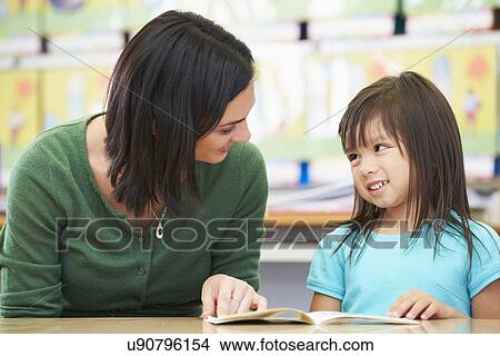 Elementary Pupil Reading With Teacher In Classroom View Large Photo Image Picture - Elementary Pupil Reading With Teacher In Classroom. Fotosearch