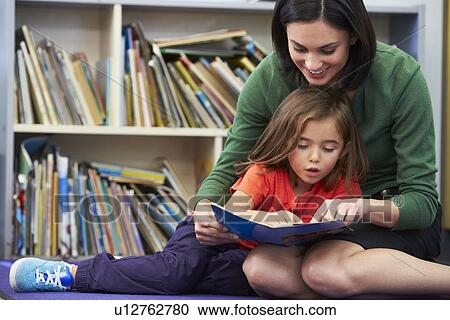 Elementary Pupil Reading With Teacher In Classroom View Large Photo Image Stock Image - Elementary Pupil Reading With Teacher In Classroom. Fotosearch