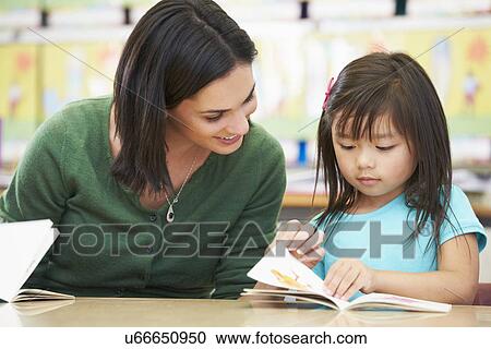Elementary Pupil Reading With Teacher In Classroom View Large Photo Image Stock Image - Elementary Pupil Reading With Teacher In Classroom. Fotosearch