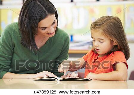 Elementary Pupil Reading With Teacher In Classroom View Large Photo Image Stock Photography - Elementary Pupil Reading With Teacher In Classroom. Fotosearch