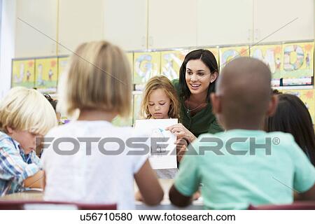 Elementary Pupil Showing Drawing To Classmates In Classroom View Large Photo Image Stock Image - Elementary Pupil Showing Drawing To Classmates In Classroom. Fotosearch