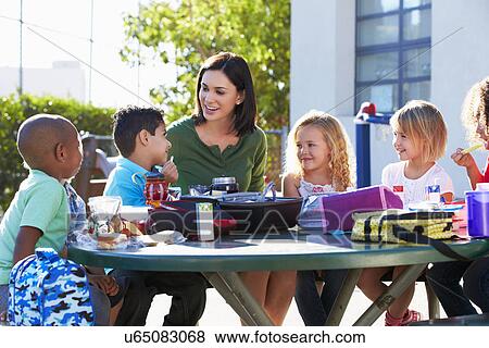 Elementary Pupils And Teacher Eating Lunch View Large Photo Image Stock Photo - Elementary Pupils And Teacher Eating Lunch. Fotosearch