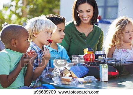 Elementary Pupils And Teacher Eating Lunch View Large Photo Image Stock Photo - Elementary Pupils And Teacher Eating Lunch. Fotosearch