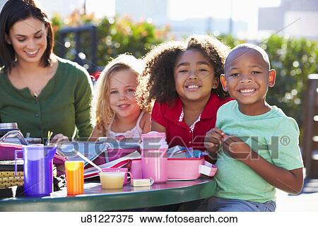 Elementary Pupils And Teacher Eating Lunch View Large Photo Image Stock Photography - Elementary Pupils And Teacher Eating Lunch. Fotosearch