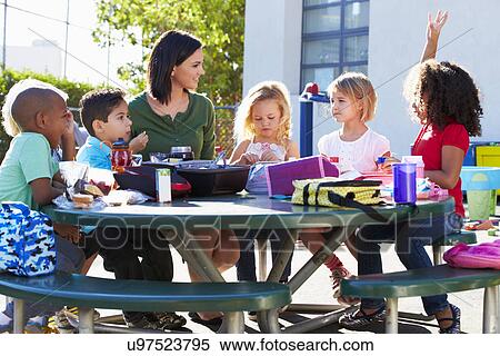 Elementary Pupils And Teacher Eating Lunch View Large Photo Image Stock Photography - Elementary Pupils And Teacher Eating Lunch. Fotosearch