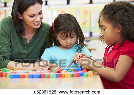 Stock Photograph - Elementary Pupils Counting With Teacher In Classroom. Fotosearch