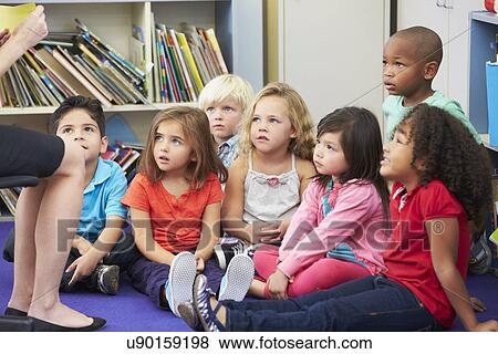 Elementary Pupils In Classroom Working With Teacher View Large Photo Image Stock Photo - Elementary Pupils In Classroom Working With Teacher. Fotosearch