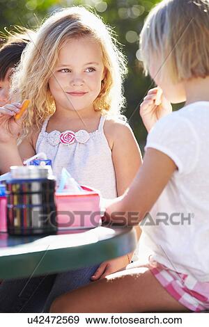Elementary Pupils Sitting At Table Eating Lunch View Large Photo Image Stock Photo - Elementary Pupils Sitting At Table Eating Lunch. Fotosearch