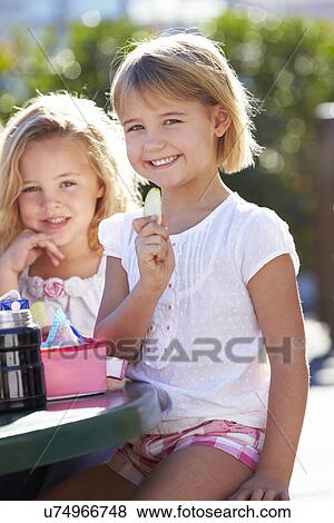 Stock Photo - Elementary Pupils Sitting At Table Eating Lunch. Fotosearch