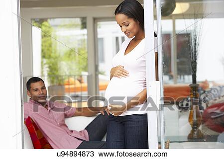 Expectant Couple Relaxing At Home Together View Large Photo Image Stock Image - Expectant Couple Relaxing At Home Together. Fotosearch