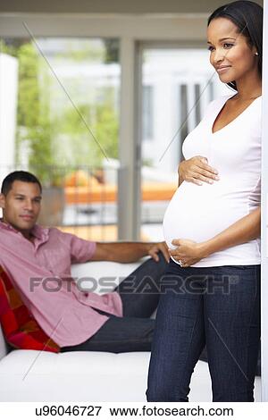 Expectant Couple Relaxing At Home Together View Large Photo Image Stock Photo - Expectant Couple Relaxing At Home Together. Fotosearch