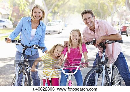 Stock Image - Family Cycling On Suburban Street. Fotosearch