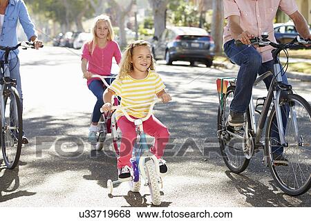 Family Cycling On Suburban Street View Large Photo Image Stock Photo - Family Cycling On Suburban Street. Fotosearch