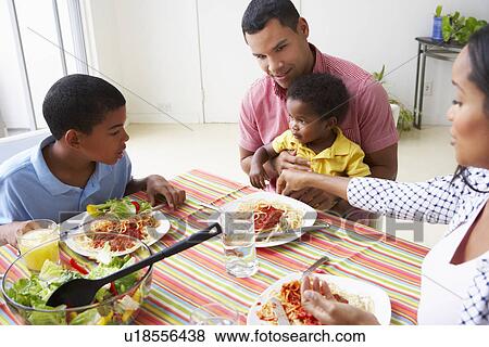 Stock Photo - Family Eating Meal Together At Home. Fotosearch