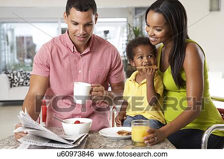 Stock Photograph - Family Having Breakfast In Kitchen Together. Fotosearch