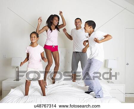 Picture - Family Jumping On Bed Together. Fotosearch