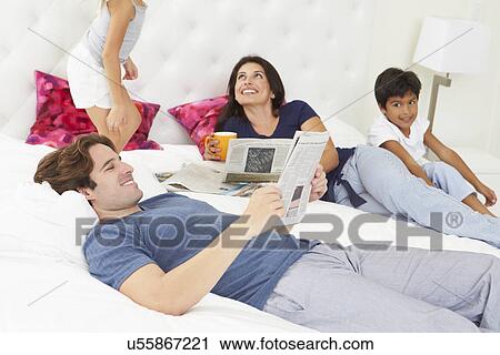 Family Relaxing In Bed With Coffee And Newspaper View Large Photo Image Stock Image - Family Relaxing In Bed With Coffee And Newspaper. Fotosearch