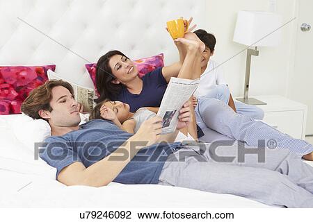 Family Relaxing In Bed With Coffee And Newspaper View Large Photo Image Stock Image - Family Relaxing In Bed With Coffee And Newspaper. Fotosearch