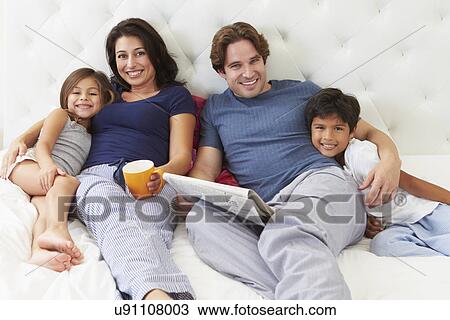 Family Relaxing In Bed With Coffee And Newspaper View Large Photo Image Stock Image - Family Relaxing In Bed With Coffee And Newspaper. Fotosearch