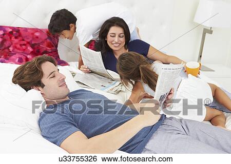 Family Relaxing In Bed With Coffee And Newspaper View Large Photo Image Stock Photograph - Family Relaxing In Bed With Coffee And Newspaper. Fotosearch