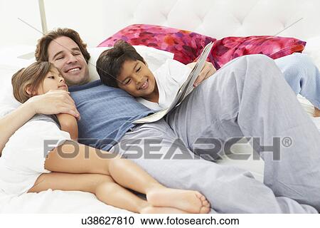 Father And Children Relaxing In Bed Together View Large Photo Image Stock Image - Father And Children Relaxing In Bed Together. Fotosearch