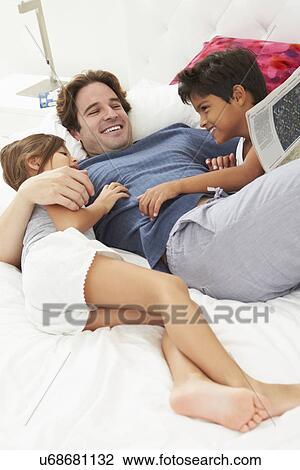 Father And Children Relaxing In Bed Together View Large Photo Image Stock Image - Father And Children Relaxing In Bed Together. Fotosearch