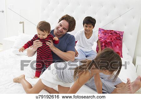 Father And Children Relaxing In Bed Together View Large Photo Image Stock Photograph - Father And Children Relaxing In Bed Together. Fotosearch