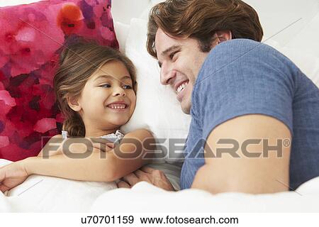 Stock Photo - Father And Daughter Lying In Bed Together. Fotosearch