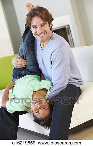 Father And Son Having Fun On Sofa Together View Large Photo Image Stock Photo - Father And Son Having Fun On Sofa Together. Fotosearch