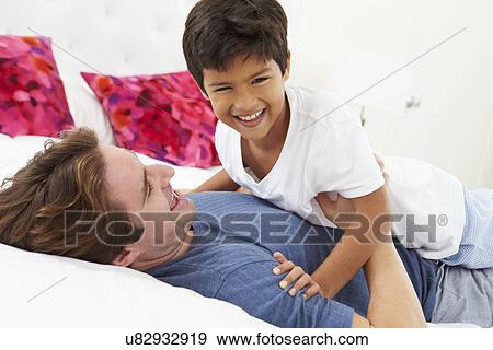 Father And Son Lying In Bed Together View Large Photo Image Stock Photo - Father And Son Lying In Bed Together. Fotosearch