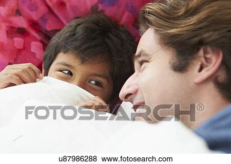 Stock Photo - Father And Son Lying In Bed Together. Fotosearch