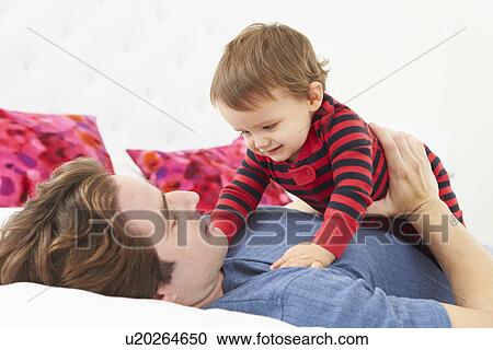 Father And Toddler Lying In Bed Together View Large Photo Image Stock Image - Father And Toddler Lying In Bed Together. Fotosearch