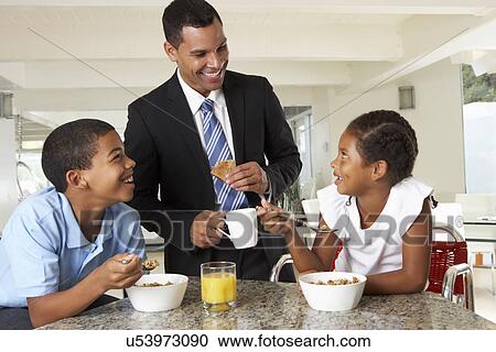 Stock Image - Father Having Breakfast With Children Before Work. Fotosearch