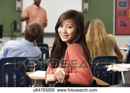 Stock Image - Female Teenage Pupil In Classroom. Fotosearch