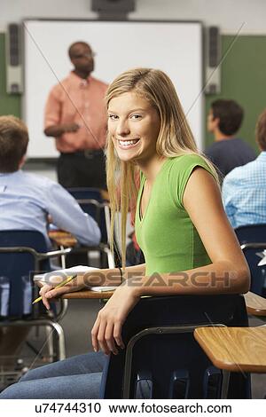 Stock Image - Female Teenage Pupil In Classroom. Fotosearch