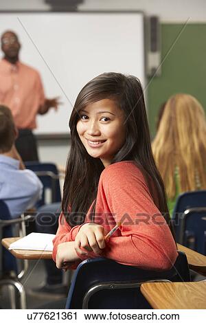 Stock Image - Female Teenage Pupil In Classroom. Fotosearch
