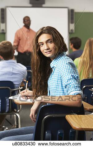 Stock Image - Female Teenage Pupil In Classroom. Fotosearch