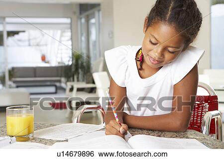Stock Photograph - Girl Doing Homework In Kitchen. Fotosearch