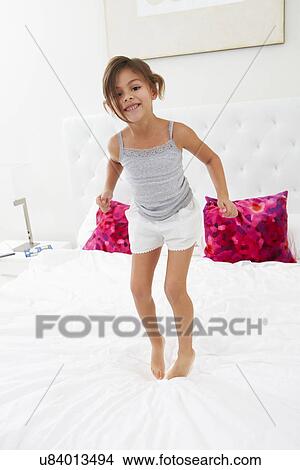 Girl Jumping On Bed Wearing Pajamas View Large Photo Image Picture - Girl Jumping On Bed Wearing Pajamas. Fotosearch
