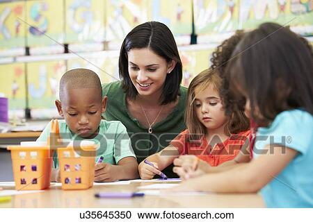 Stock Image - Group Of Elementary Age Children In Art Class With Teacher. Fotosearch