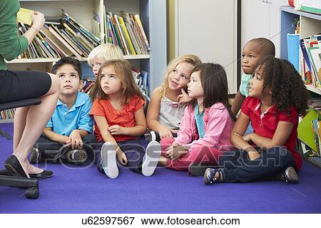Stock Photo - Group of Elementary Pupils In Classroom Working With Teacher. Fotosearch