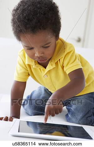 Happy Boy On Sofa Playing With Digital Tablet View Large Photo Image Picture - Happy Boy On Sofa Playing With Digital Tablet. Fotosearch